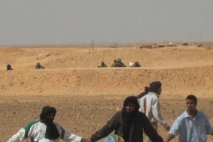 Ao fondo, militares marroqu&iacute;s vix&iacute;an a manifestaci&oacute;n