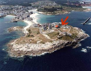 Na Atalaia, a car&oacute;n do Faro, sinalada cunha seta a zona na que se atopou o xacemento, e cunha estrela laranxa o edificio que nunca foi habitado